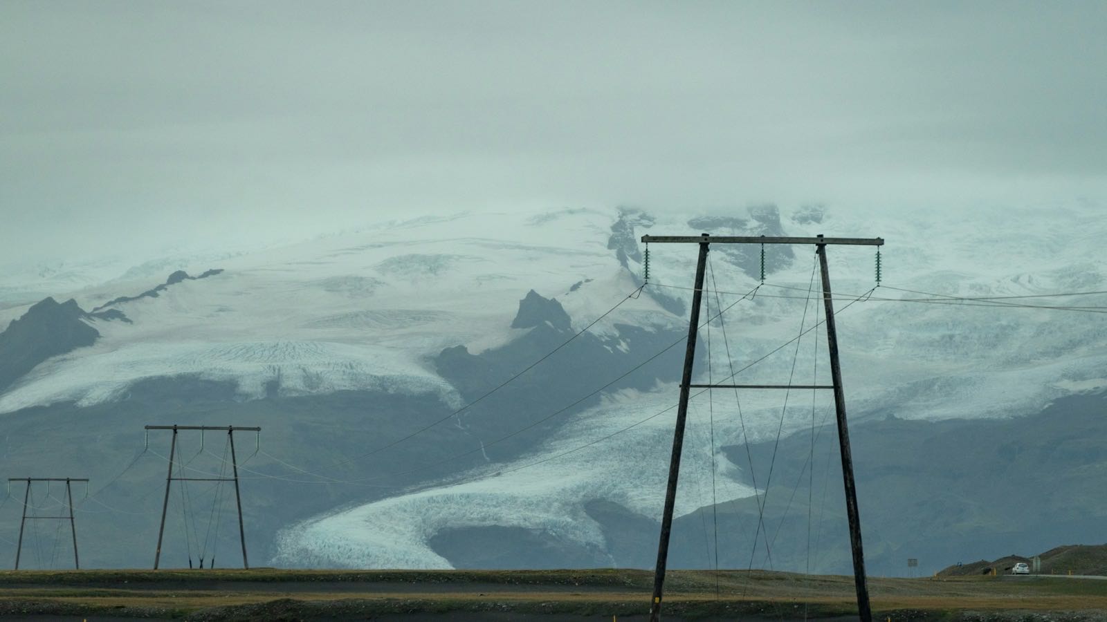 Kraftlinje foran en snødekt isbre