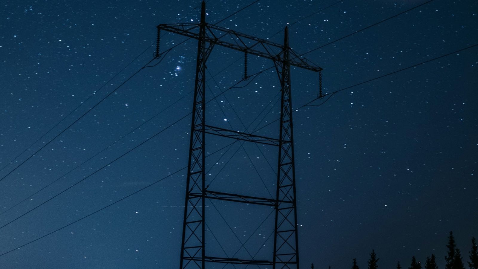 Høyspentmast mot stjernehimmel en vinternatt i Norge